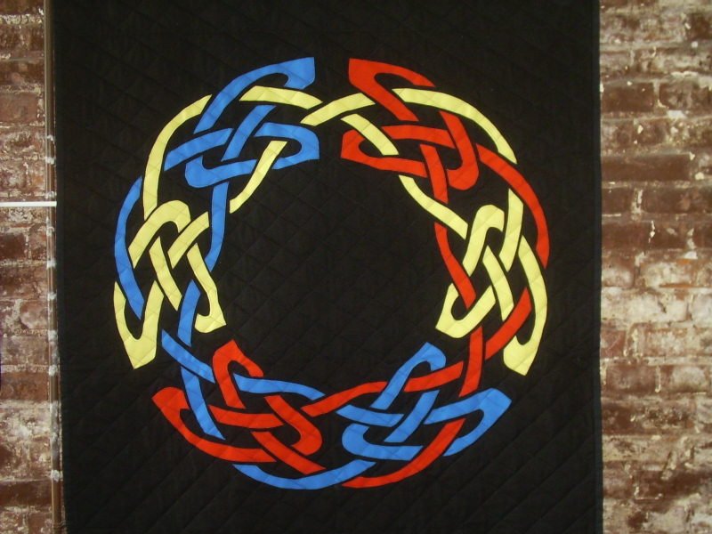 Red, yellow, and blue circular Celtic knot.