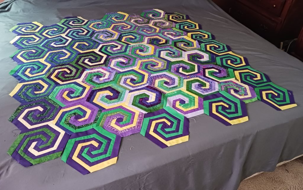 Interlocking yellow, green, and purple spirals.