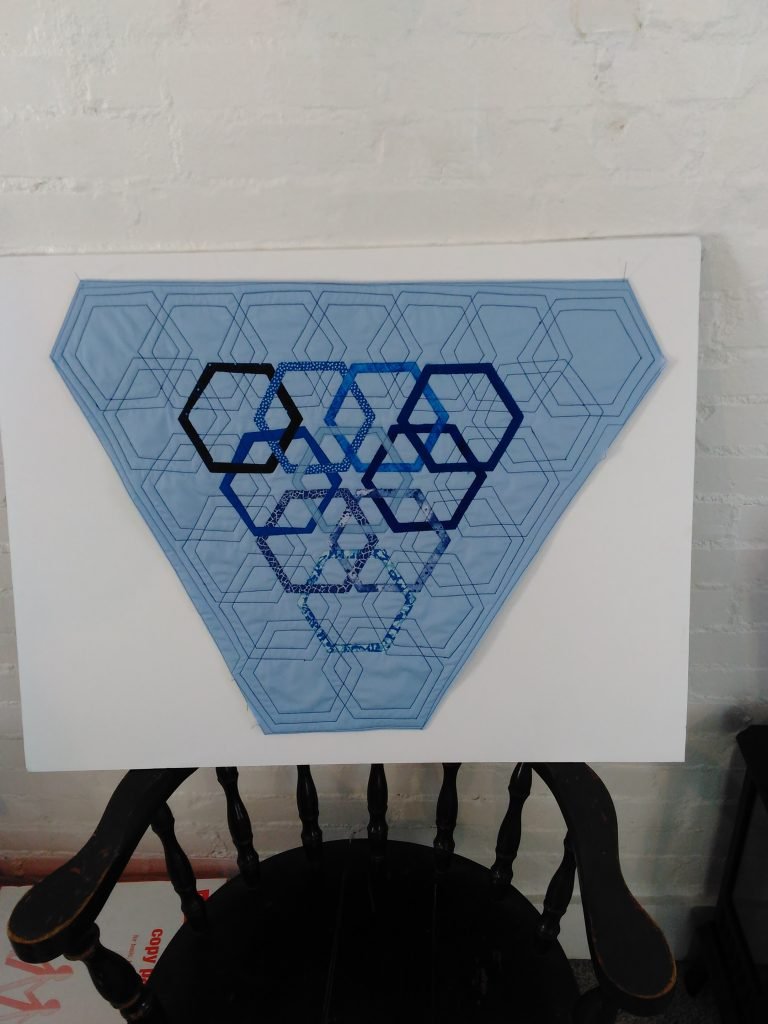 Interwoven hexagonal shapes surrounded by interwoven hexagonal outlines.