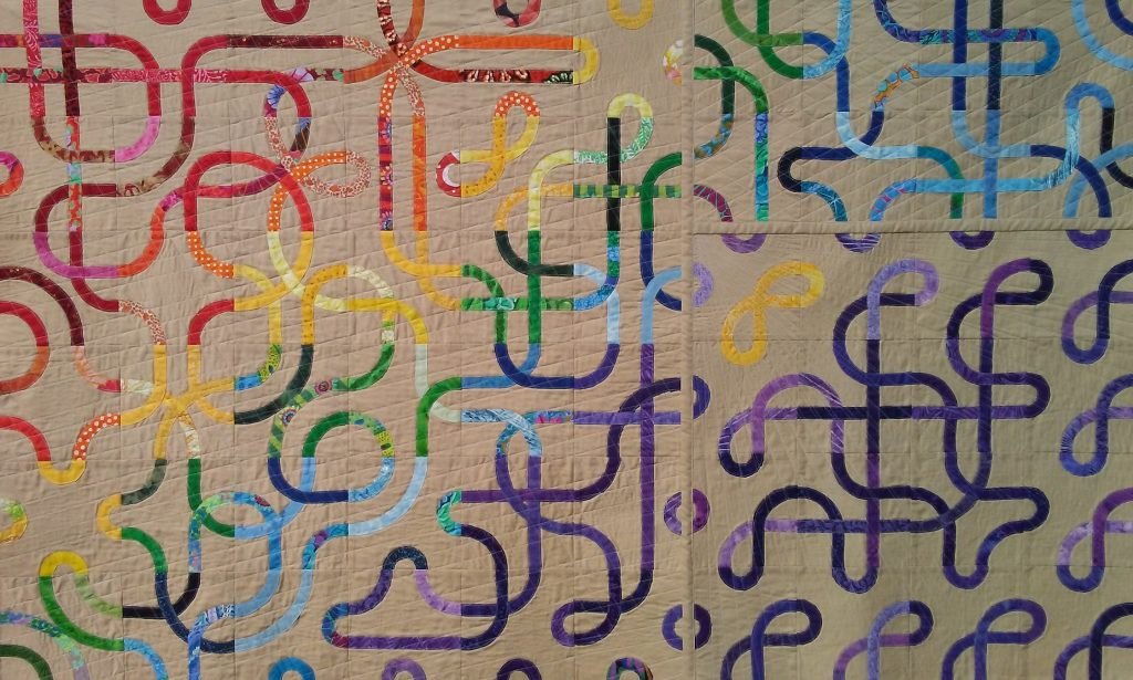 Multi-colored knotwork on brown background.